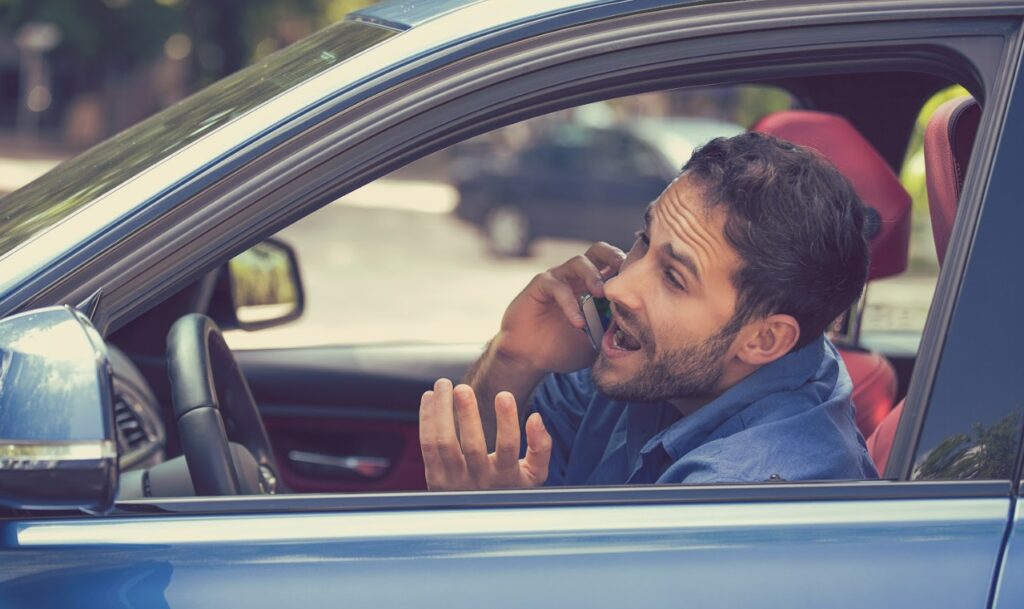 Man on phone while driving, illustrating distracted driving. Distracted driving statistics show the risks of this behavior.